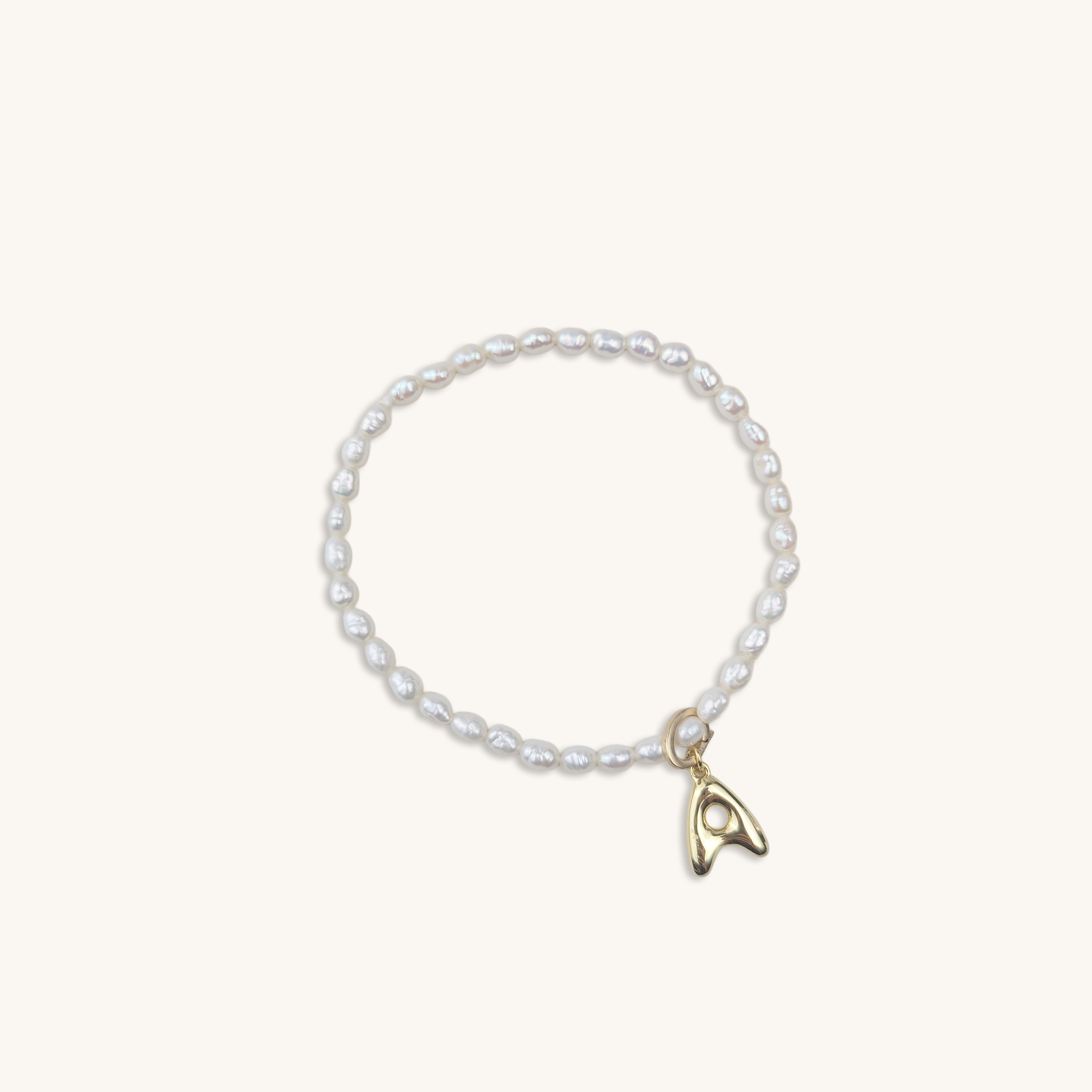Pearl bracelet with a gold charm on a white background